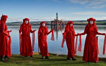 Red robed protesters from Extinction Rebellion take part in blockading the oil rig maintenance facility at Cromarty Firth Port Authority