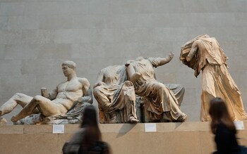 Visitors walk past sculptures that are part of the Parthenon Marbles at the British Museum in London
